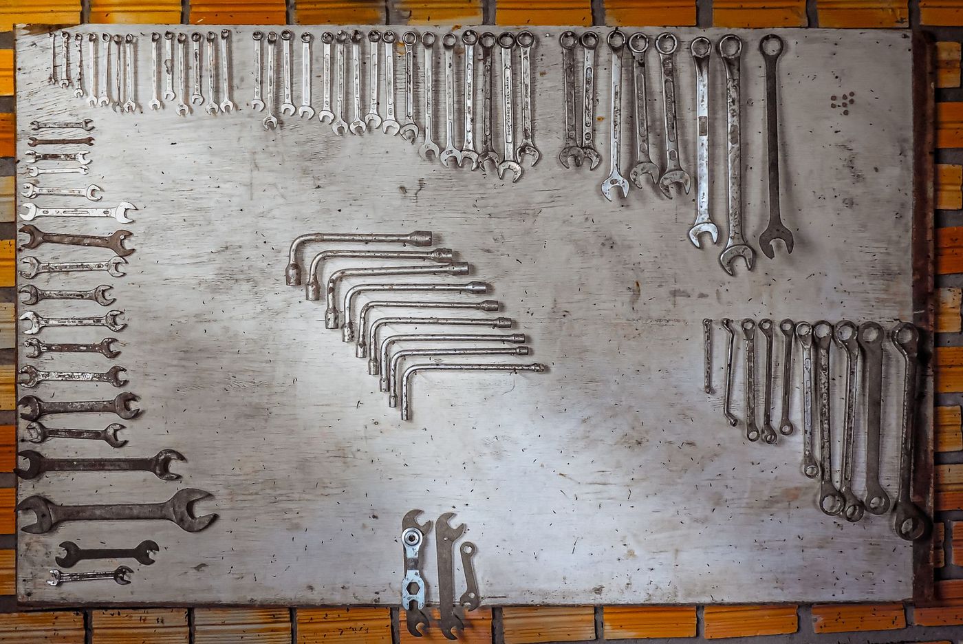Wrenches laid out in order on a workshop tool board